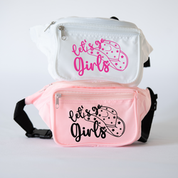 Two bachelorette pink and white fanny packs with lettering that read 'Let's Go Girls' on them, with a cowgirl hat with stars next to the wording.